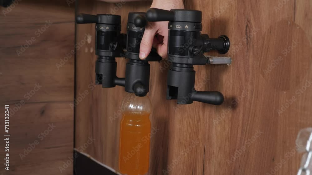 The bartender pours fresh craft beer into a plastic bottle at the bar. Draft light beer. A man is bottling beer. An automated method for bottling fresh beer. The bartender pours fresh craft beer into a plastic bottle at the bar. Draft light beer. A man is bottling beer. An automated method for bottling fresh beer.