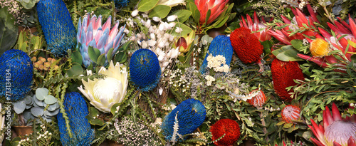 Flowers wall background with amazing red, pink and blue protea and banksia flowers, hand made Wedding decoration, Valentine background. Colorful tropical flowers mix. Pattern tropical flowers. NO AI.