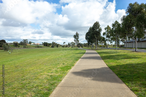 Background of a walking trail in a large open outdoor green space in a suburban neighbourhood. A public park with grass lawn in Melbourne's residential suburb. Williams Landing, VIC Australia.