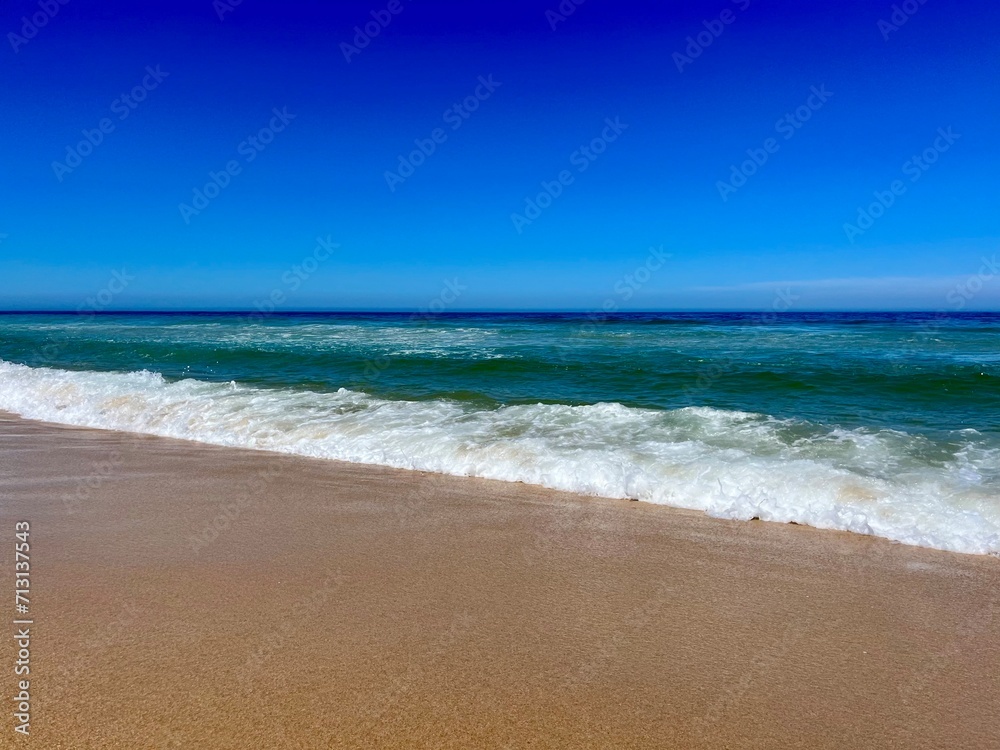 Blue seascape background, clear blue sky and blue sea horizon, sandy coastline