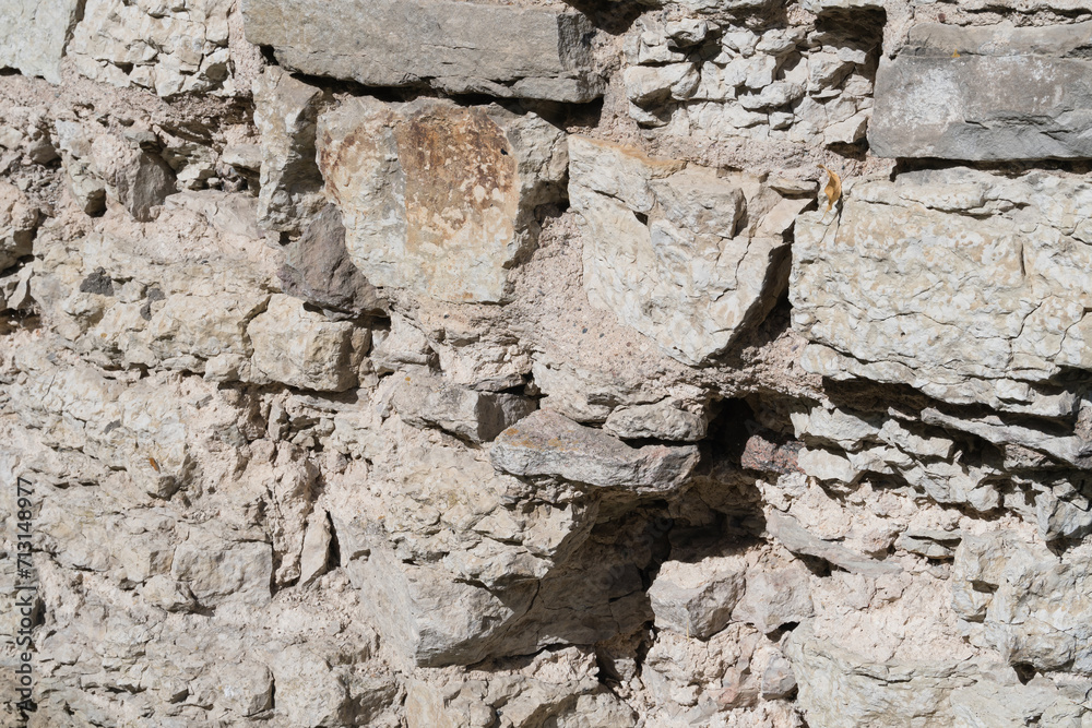 Structural background from a fortress wall made of natural stone.