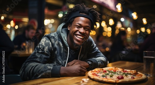 A content man, dressed in casual clothing, sits at a table inside a fast food shop, a smile spread across his face as he eagerly awaits his delicious pizza