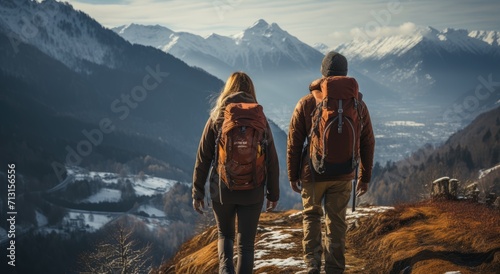 Two mountaineers brave the harsh winter elements as they stand atop a snow-covered summit, their jackets and backpacks signaling their love for the outdoors and determination to conquer the mountain  photo