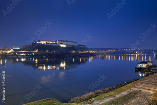 Selective blur on Petrovaradin Fortress in Novi Sad, Serbia by the danube river at night with a banner indicating novi sad is the european capital of culture. This castle is main landmark of Vojvodina