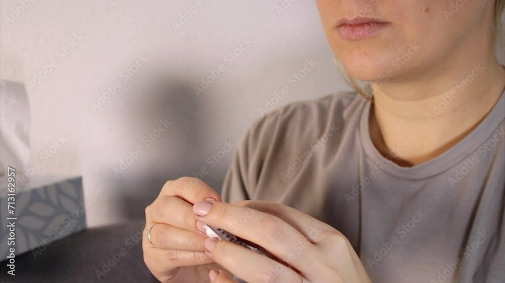 Close up of sick woman taking a white headache pill out of a pack and putting in her mouth 