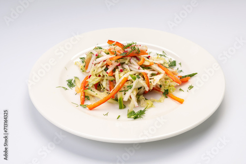 Dinner. Vegetable salad on a white plate and a white background.
