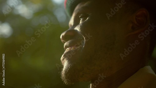 Side View Of African Warrior From Karamoja Smiling With Sunlight On His Face. - close up shot photo