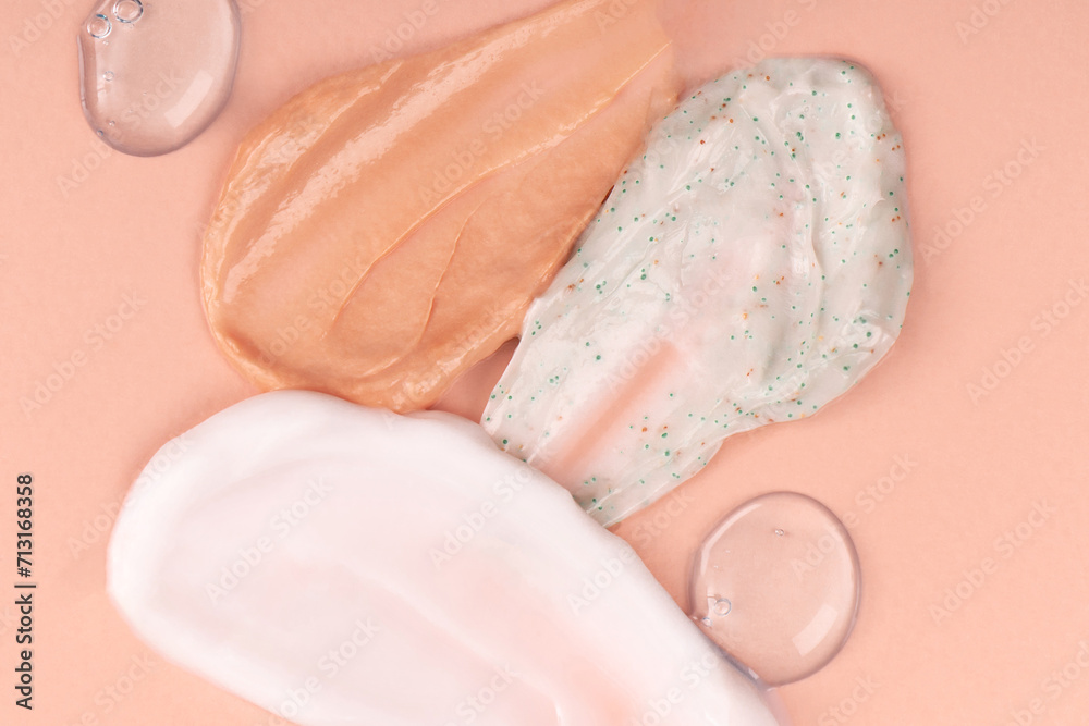 Fototapeta premium Different smears and drops of cream on a beige background. Skin care cosmetics cream, scrub, powder. Cream textured cosmetic background.