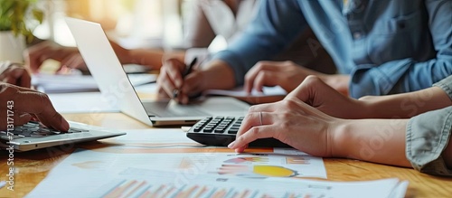 Business team meeting using calculator Work with charts and analyze business strategies financial statistics sitting at the desk vertical view. Copy space image. Place for adding text photo
