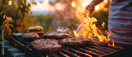 a man puts burger buns on the grill of a gas grill A gas grill is installed in the backyard of the household interesting pastime with family and friends. Copy space image. Place for adding text photo
