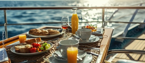 A full room service breakfast on a balcony of a cruise ship cabin at sea including juice coffee and full meals on a sunny luxury vacation on the sea. Copy space image. Place for adding text photo