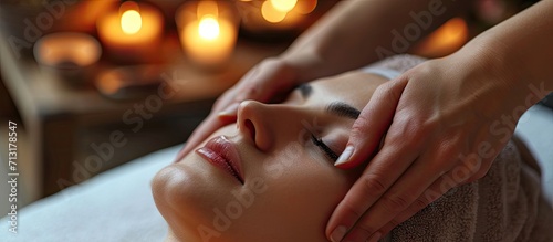 Hands of cosmetologist making manual relaxing rejuvenating facial massage for young woman in beauty salon Rejuvenating facial massage in cosmetology. Copy space image. Place for adding text