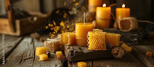 Honeycombs in jars and candles with different patterns handmade with beeswax on wood. Copy space image. Place for adding text
