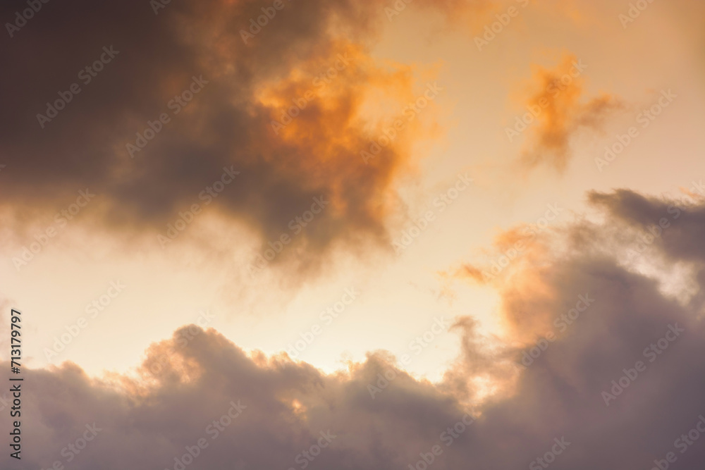 evening sky in orange glow. huge fluffy clouds. dramatic natural background in summer