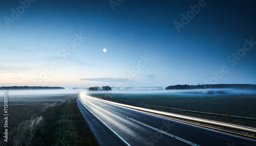 Moonlit Journey: Panoramic View of an Empty Highway Through Foggy Fields at Night