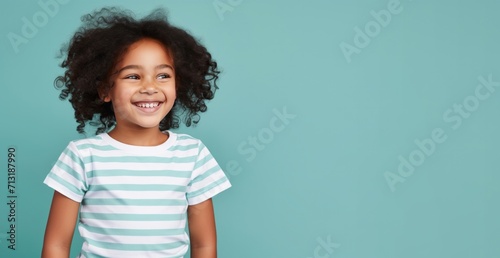 portrait beautiful afro american child girl dressed in t-shirt and smiling, light background