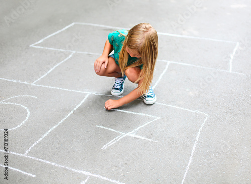 Kid playing hopscotch on playground outdoors photo