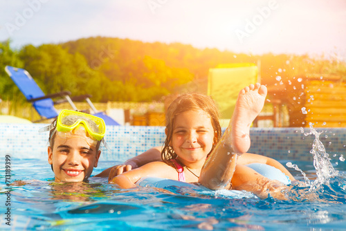 Children playing in pool. Two little girls having fun in the pool. photo