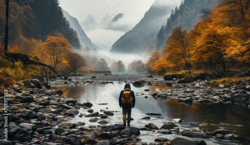 Amidst the serene autumn landscape, a solitary figure stands in the river, enveloped by fog and surrounded by towering trees, their reflection dancing on the calm waters, lost in the beauty of nature