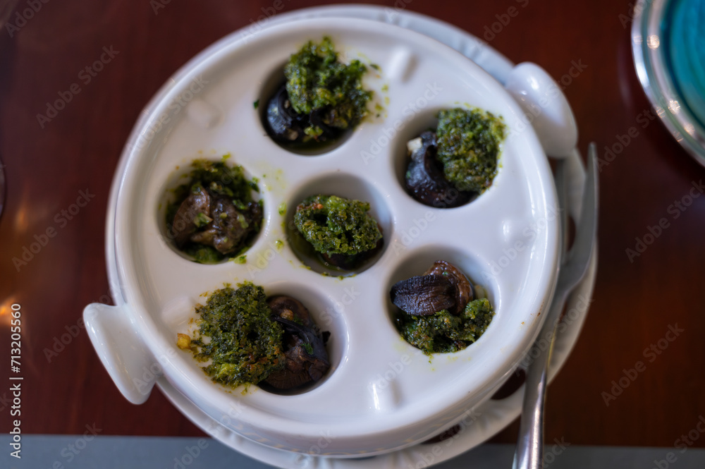 Starter dish in traditional restaurants on Burgundy, snails cooked with butter, garlic and herbs, France Starter dish in traditional restaurants on Burgundy, snails cooked with butter, garlic and herbs, France
