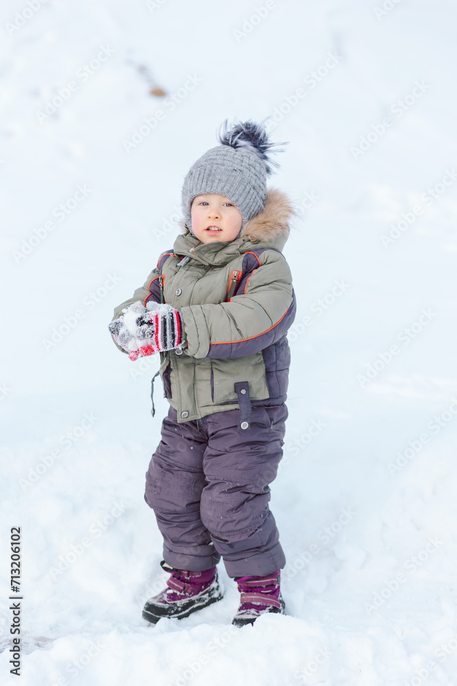 Baby enjoys winter playing snowballs Baby enjoys winter playing snowballs