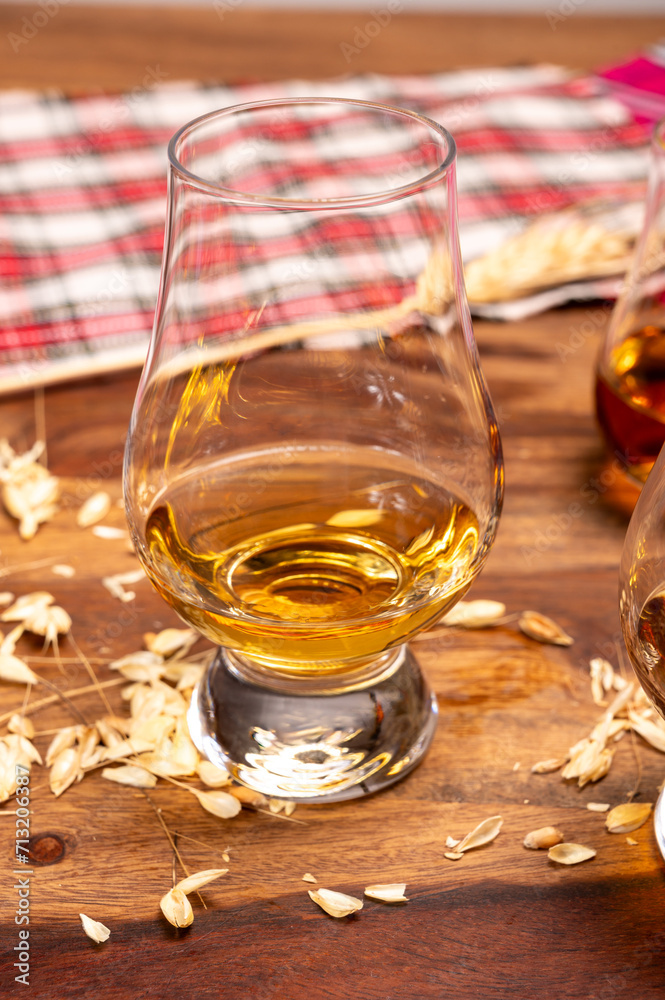 Tasting of different Scotch whiskies strong alcoholic drinks, drum of whiskey and colorful Scotch tartan on background close up Tasting of different Scotch whiskies strong alcoholic drinks, drum of whiskey and colorful Scotch tartan on background close up