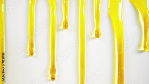 Golden honey or oil flows down on white background. photo