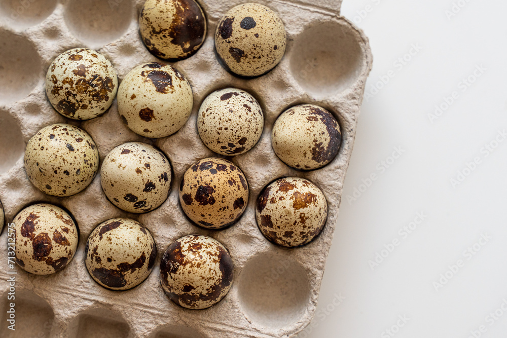 Spotted quail eggs in an egg box on a yellow background, natural eco friendly products. Spotted quail eggs in an egg box on a yellow background, natural eco friendly products.