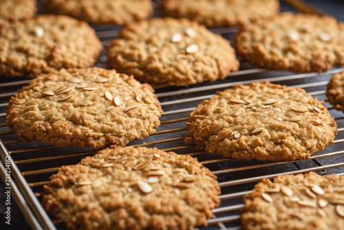 Freshly baked Anzac biscuits cooling on the rack, a golden blend of oats and coconut.