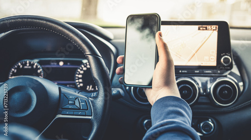 Teen drive a car and use smartphone. Young man reading messages holding a cell phone while driving. Dangerous behavior, accident risk. Danger, transgression, youth, distraction concept. Focus on hand. photo