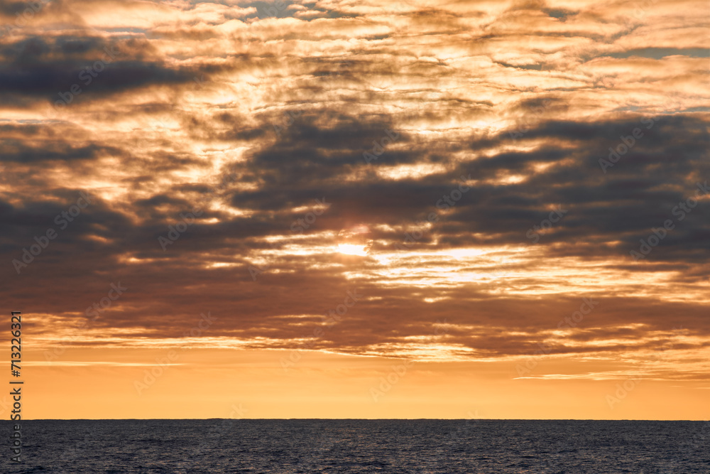 Obraz premium Beautiful colourful sunset sky with yellow clouds in the sea.