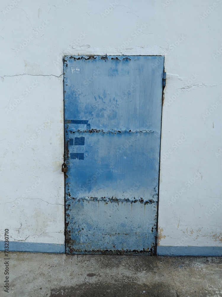 Rusty blue iron door commonly used in old textile factories Rusty blue iron door commonly used in old textile factories