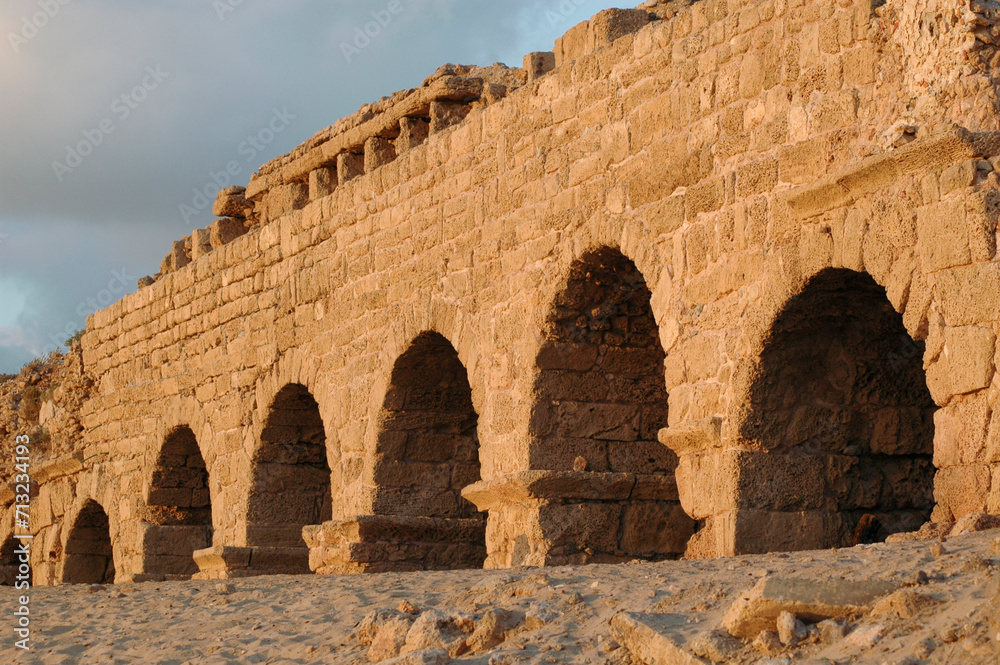 Golden sunlight strikes the stones of the Hadrianic aqueduct of Caesarea Maritima along Israel's Mediterranean coast.