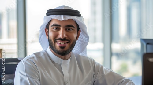 Happy Arab man in office dressed in kandura photo
