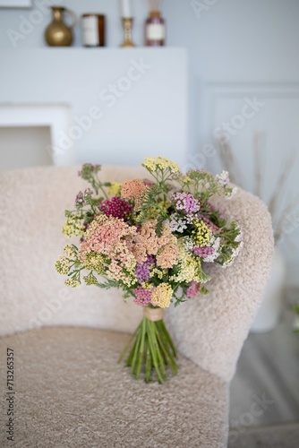 Beautiful bouquet of wild flowers. Stylish chair in the background.