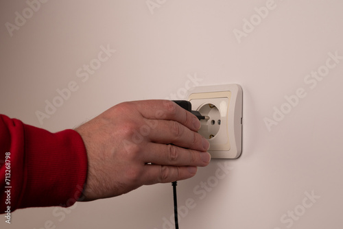 Different standards for electrical outlets. Unsuitable connector and plug in the hand of a person. Incompatibility, concept