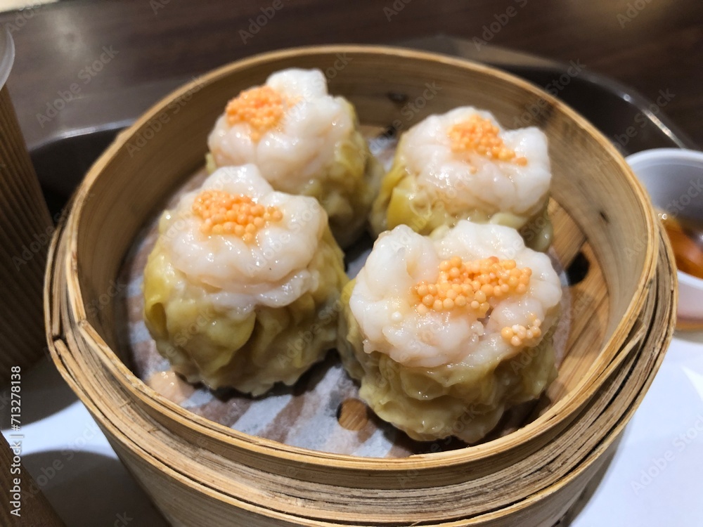 Dim Sum Steamed Pork Dumplings (Shu Mai) in bamboo steamer. Yumcha, Cantonese food style. Chinese cuisine. Dim Sum Steamed Pork Dumplings (Shu Mai) in bamboo steamer. Yumcha, Cantonese food style. Chinese cuisine.