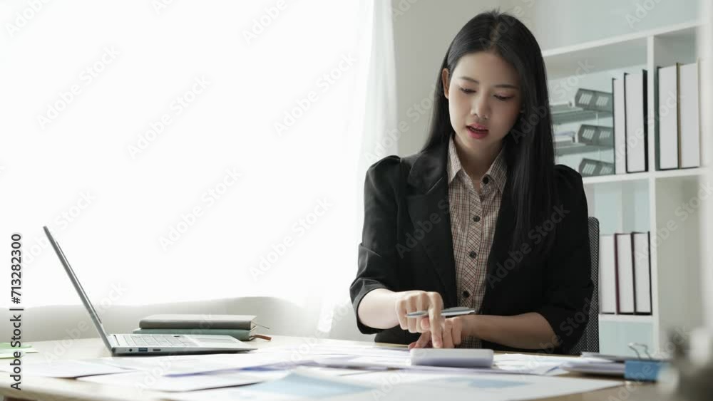 Young Asian business woman doing statistics planning and holding a chart, graph tablet and staff taking notes. Financial statistics success concept, 4k video Young Asian business woman doing statistics planning and holding a chart, graph tablet and staff taking notes. Financial statistics success concept, 4k video