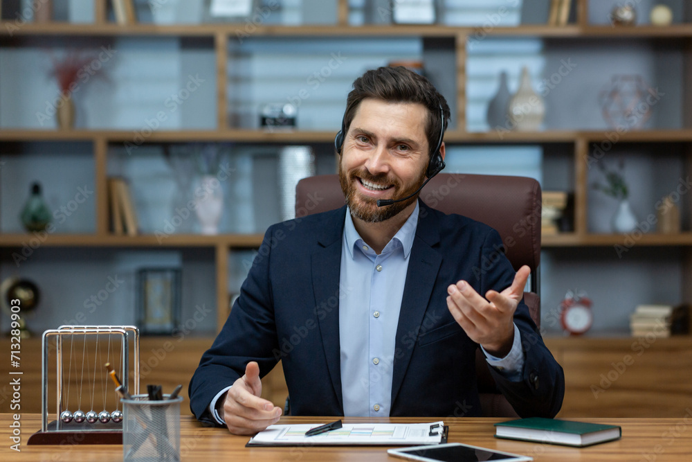 Experienced mature man in a suit and headset working from a well-organized home office, exuding confidence and charisma. Experienced mature man in a suit and headset working from a well-organized home office, exuding confidence and charisma.