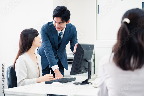 女性上司に報告をする若いビジネスマン photo