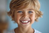 Close-up of a bright smiling European boy child showing off healthy white teeth