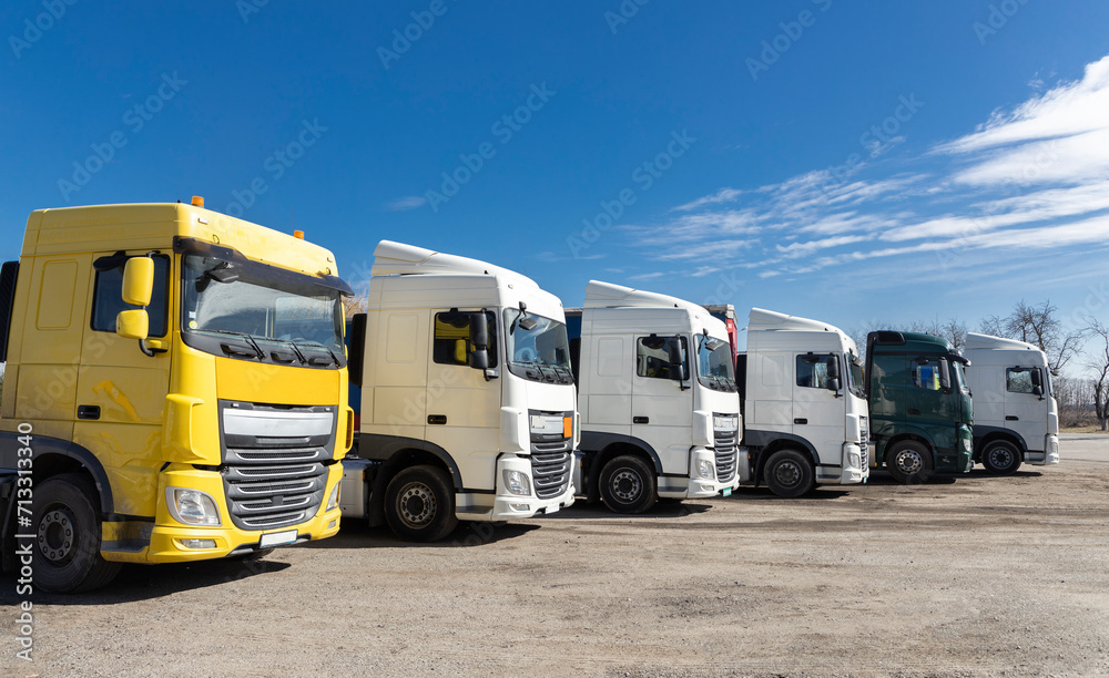 6 trucks parked beautifully in a row on a sunny day. view of the cabs of different colors of tractor-trailers. Commercial vehicles, advertising of cars for business transportation