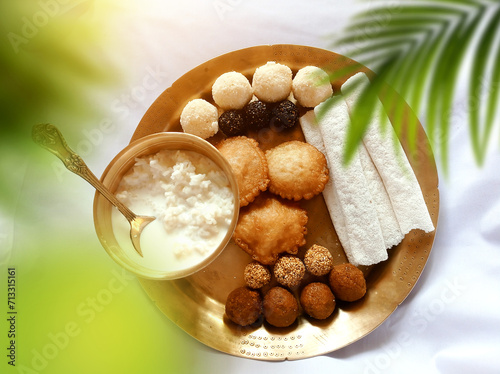 Assamese traditional food items like pitha, laddu, doi sira with assamese gamosa background with japi motifs photo