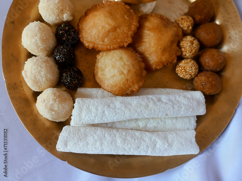 Assamese traditional food items like pitha, laddu, doi sira with assamese gamosa background with japi motifs photo
