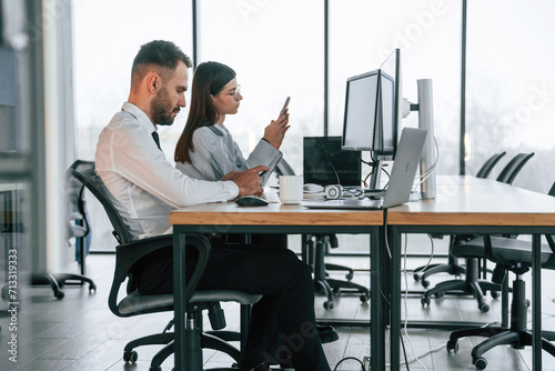 In formal clothes. Brokers doing research. Two employees are working in the office together