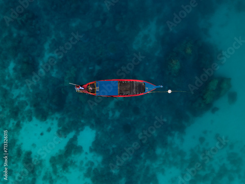 Obraz na płótnie View from above, stunning aerial view of a long tail boat floating on a turquoise water. Phuket, Thailand. w salonie