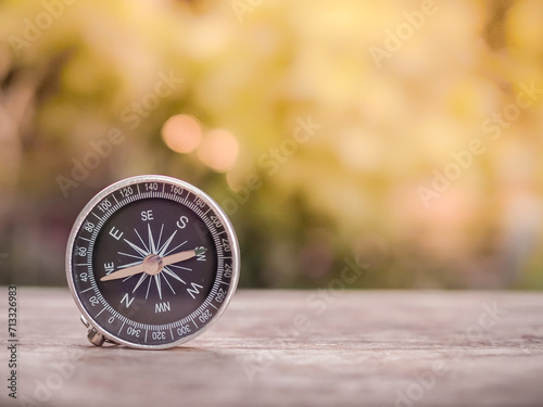 Close up compass on table in the sunset time. The concept of world tourism day, Searching the right directions and Travel