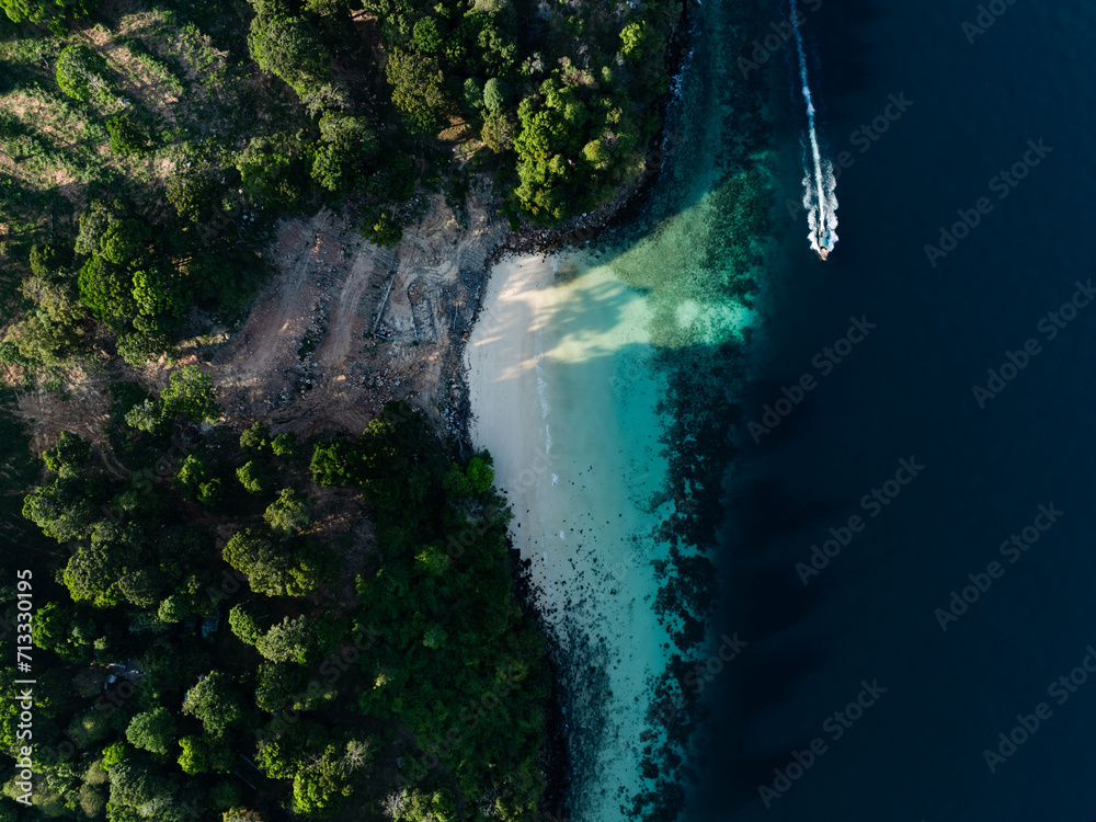 View from above, stunning aerial view of a longtail boat sailing on a turquoise water. Phuket, Thailand.
