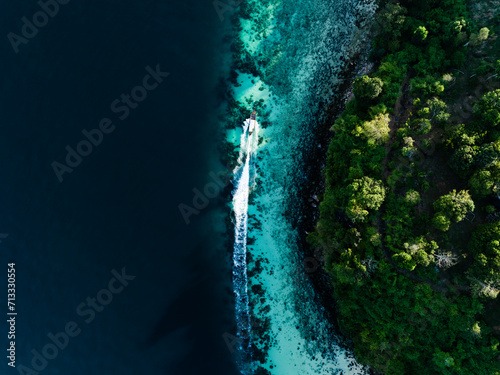View from above, stunning aerial view of a longtail boat sailing on a turquoise water. Phuket, Thailand. © Travel Wild