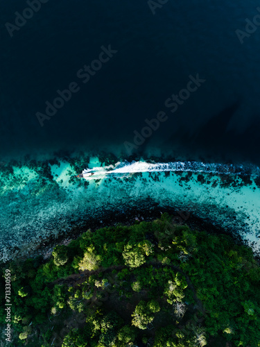 Obraz na płótnie View from above, stunning aerial view of a longtail boat sailing on a turquoise water. Phuket, Thailand. w salonie